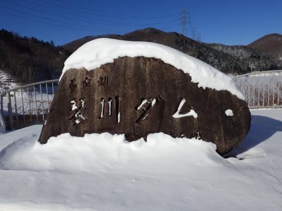 琴川ダムの名称の石碑に雪が積もった写真